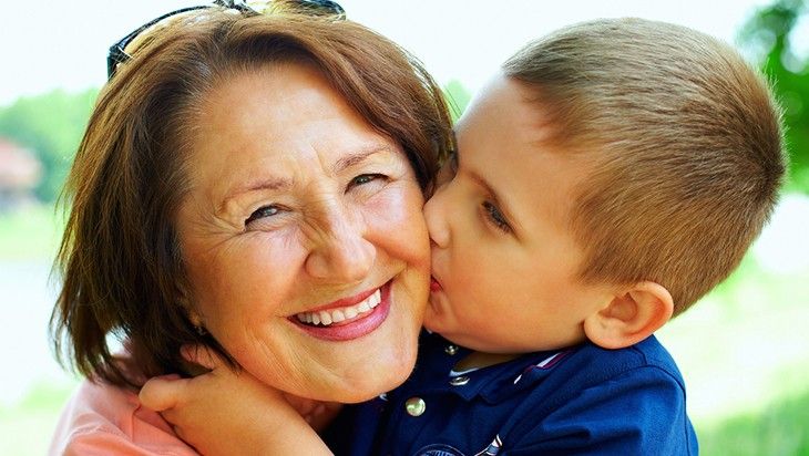 little boy kissing grandma on her cheek