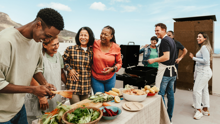 Happy multigenerational people having fun doing barbecue grill at house rooftop