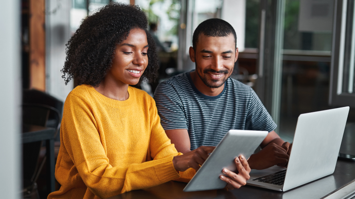 Young couple using digital tablet in café