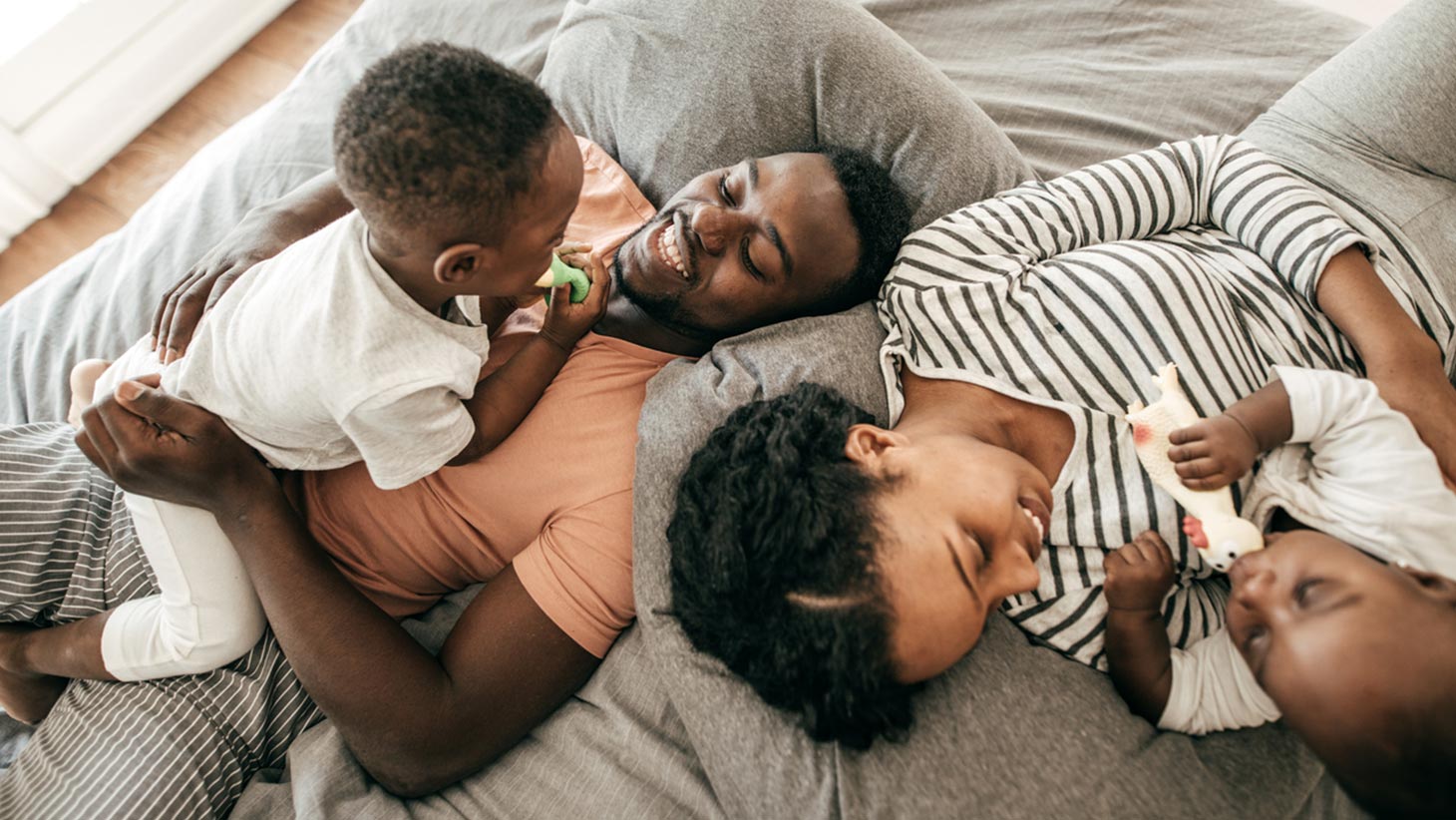 Young family laying down with 2 kids