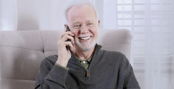 An elderly man talking on the phone