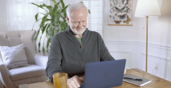 An elderly man working on his laptop